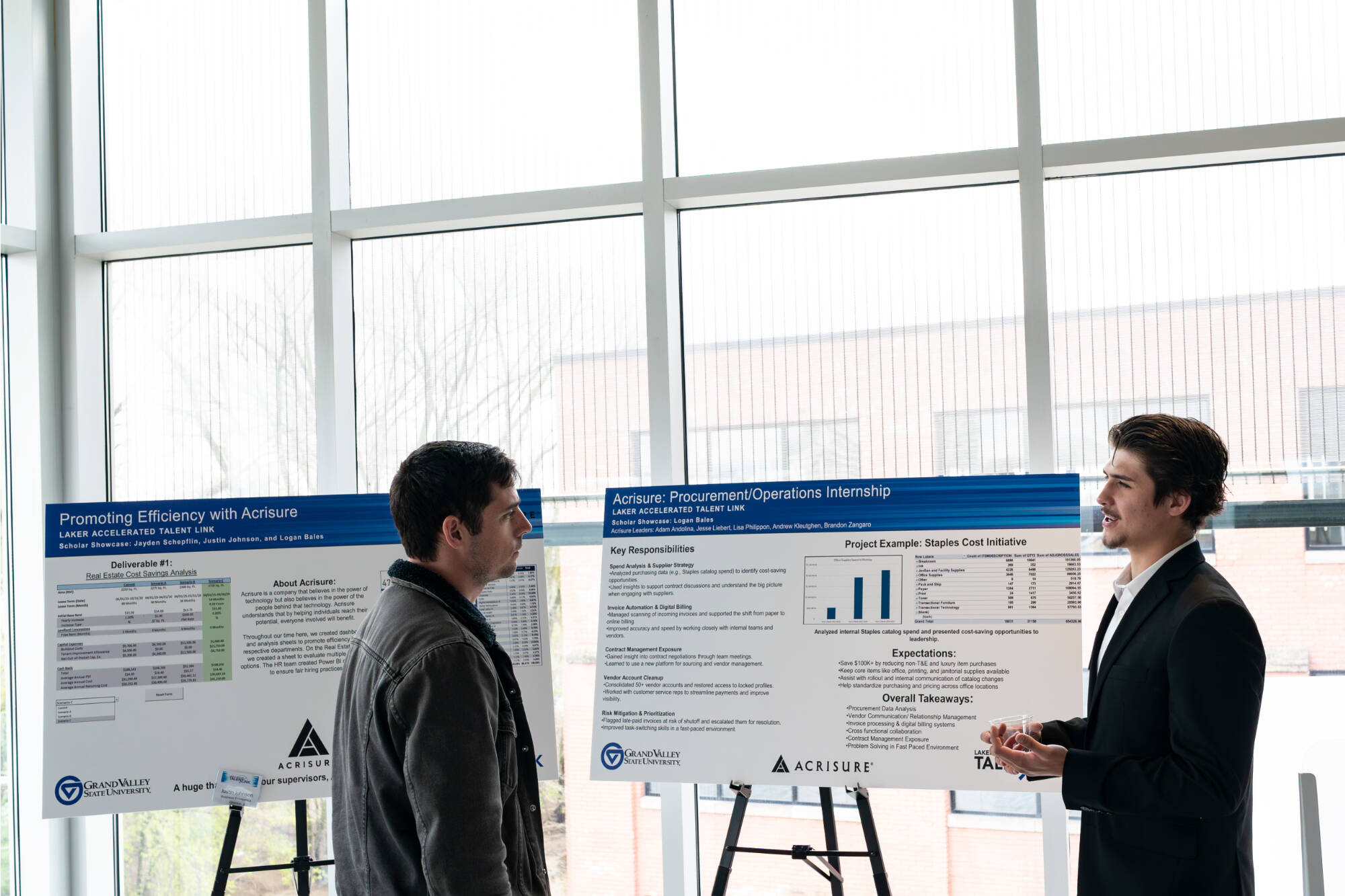 GVSU graduate Logan Bales, right, talks with John Wiegand